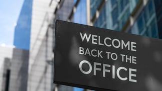 Sign posted on commercial building reading "Welcome Back to the Office"
